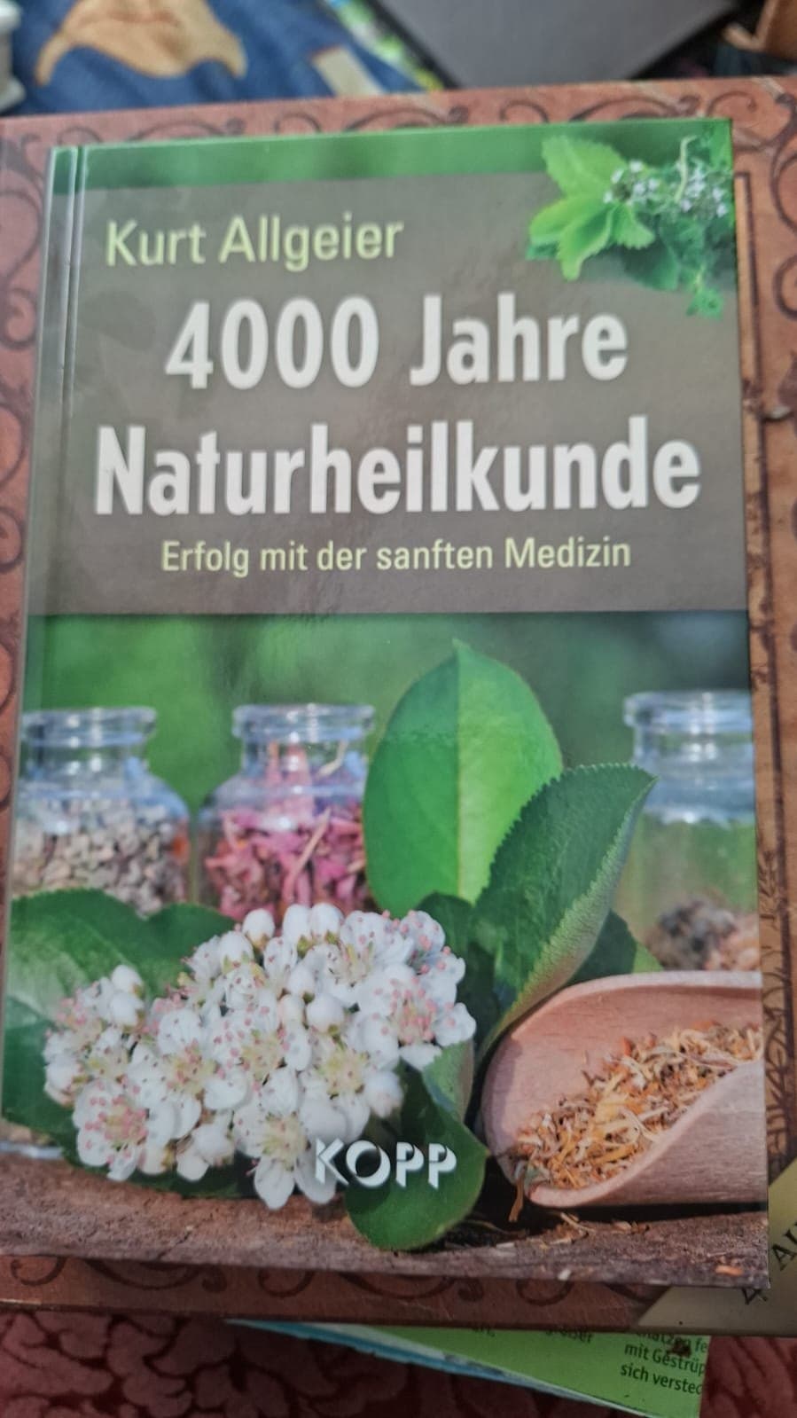 Buch mit Foto von Kräutergläsern auf dem Einband